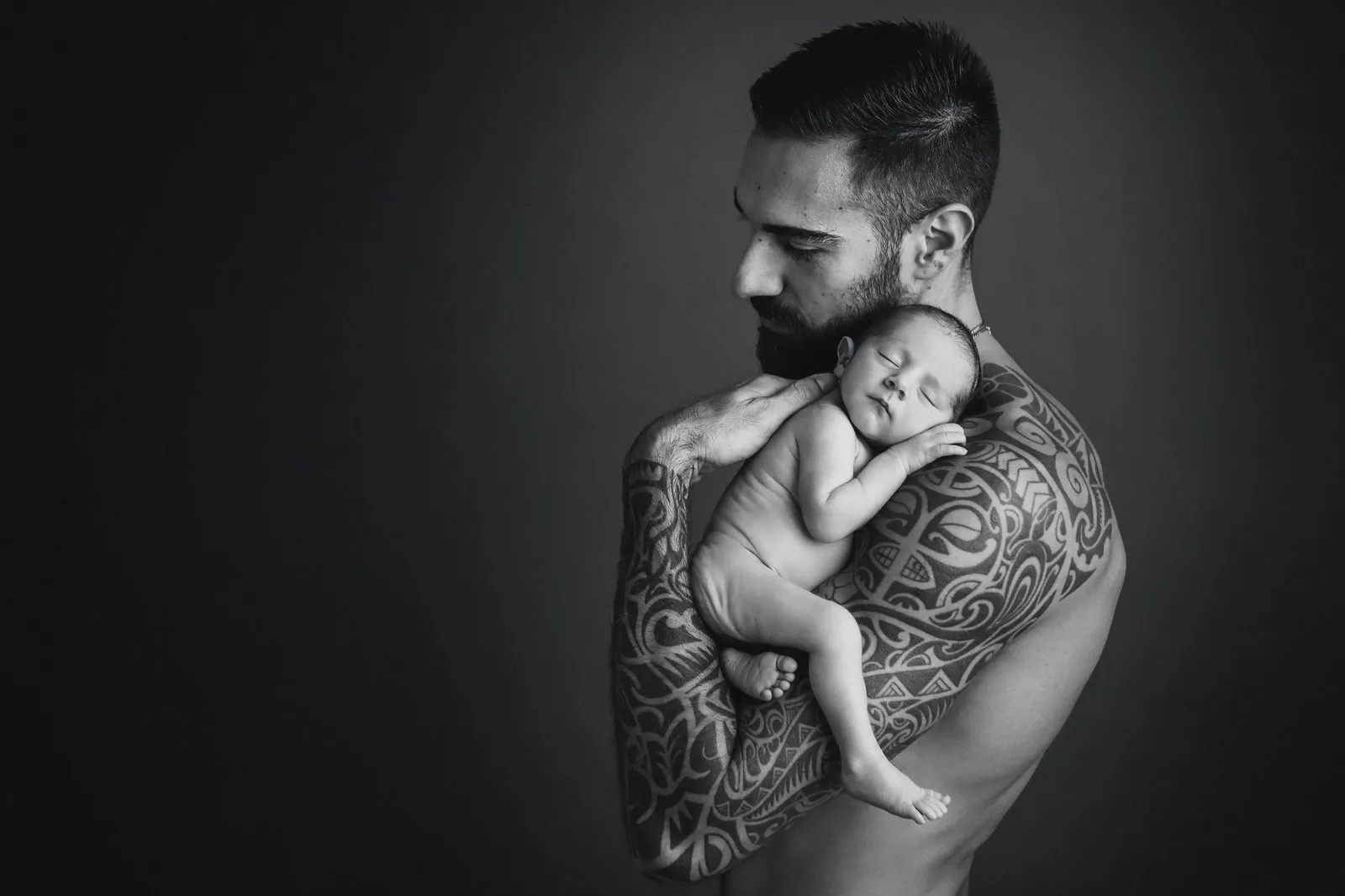 Crno-bijeli portret tate koji drži novorođenu bebu — Newborn Studio Devine